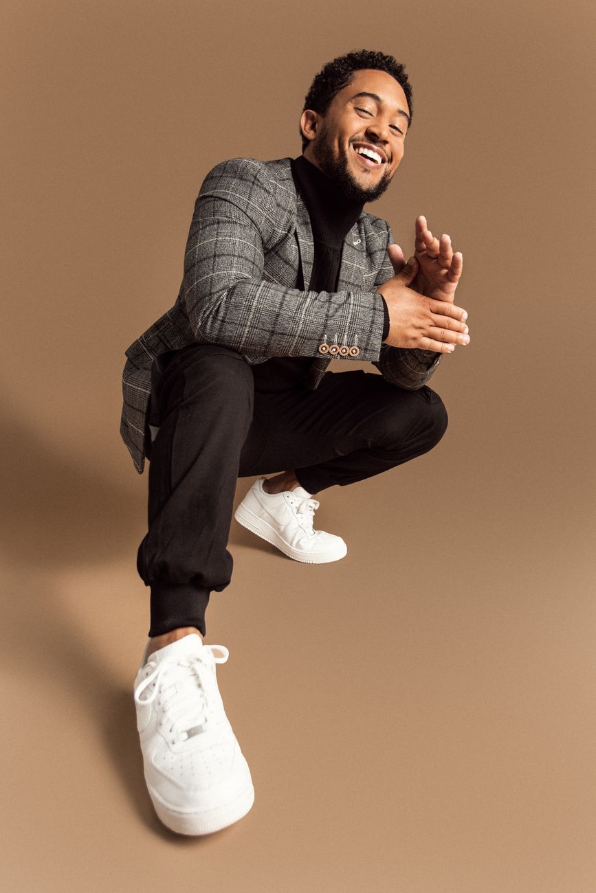 Menswear styling: a grey checked blazer, black trousers, and white sneakers