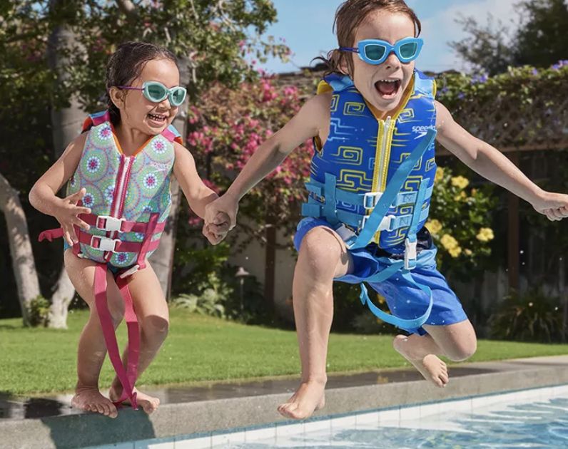 Swim campaign: two children in printed life vests jumping into a pool