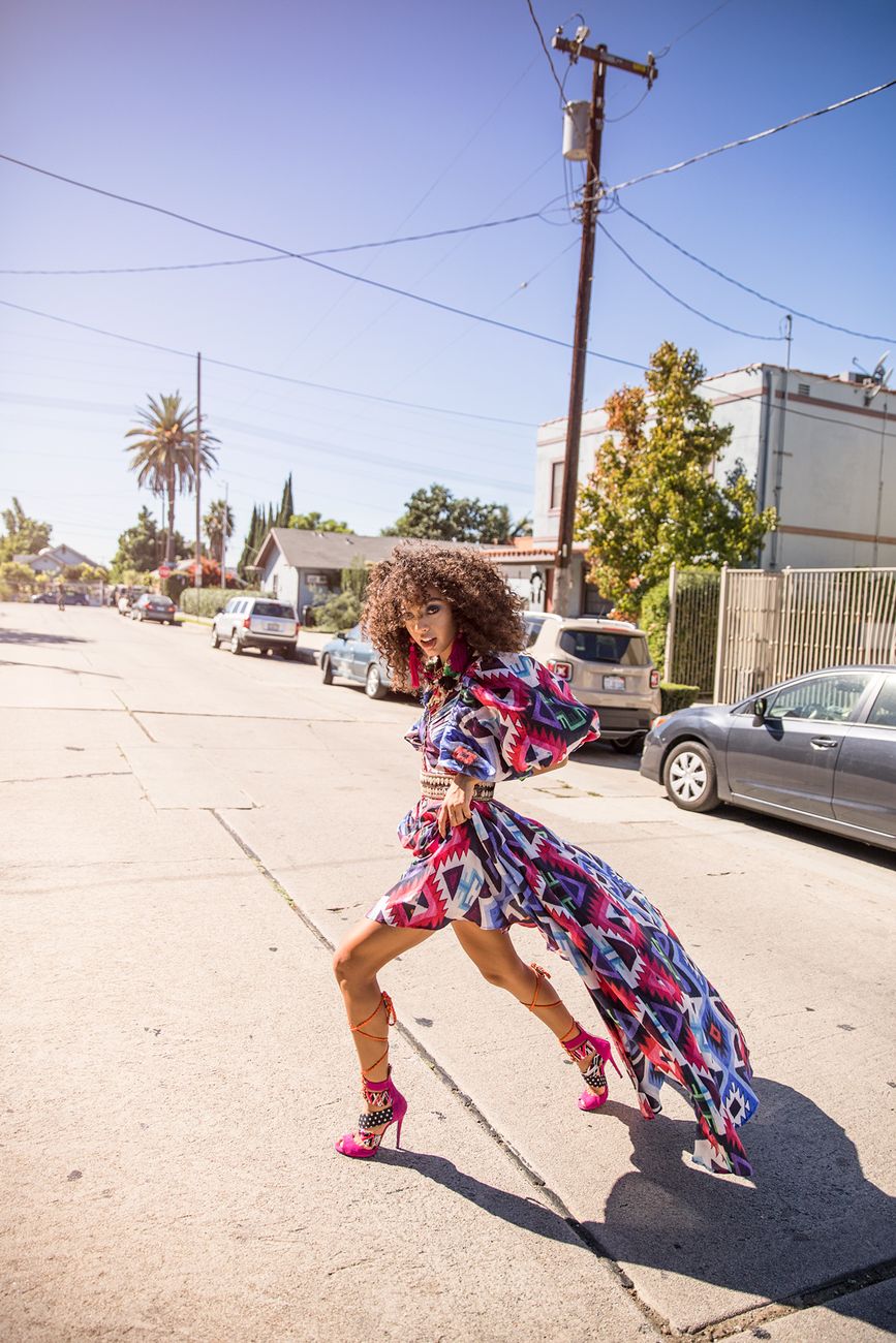 Editorial: a bold printed gown caught in motion on a sunlit street